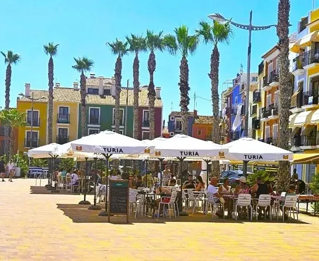 Holidaymakers enjoying al fresco lunch at Villajoyosa seafront.