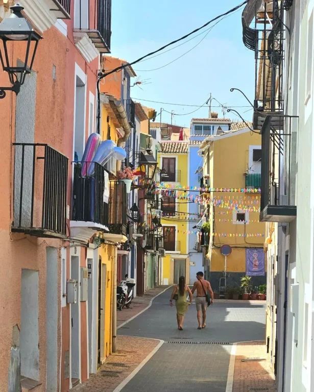 A couple holding hands walking the streets of Villajoyosa Old Town.